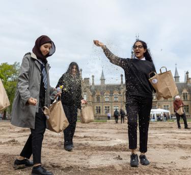 Teenage school girls throwing seeds